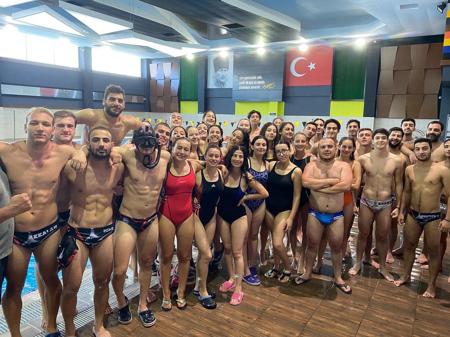 Antrenman kampında bir araya gelen sporcular havuz başında toplu fotoğrafta